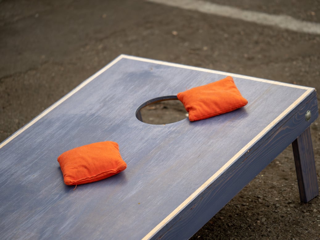 Orange Beanbags Sitting on Blue Cornhole Board Platform